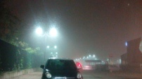 Nebbia, in un parcheggio, di sera.